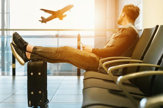 Man In Airport Waiting For Boarding On Plane