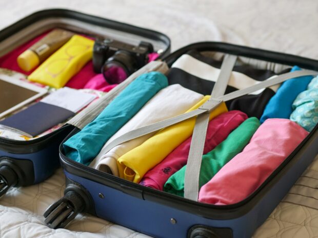 Rolled Clothes Packing Inside A Suitcase - Blue Luggage With Folded Clothes