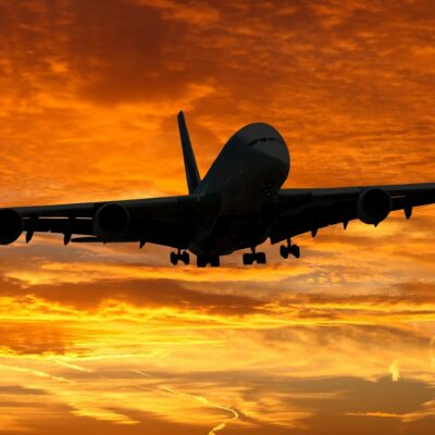 Airplane Landing At Sunset