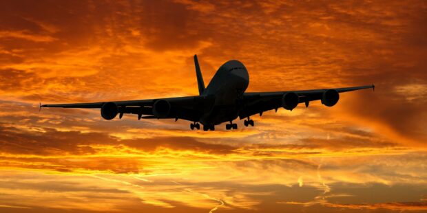 Airplane Landing At Sunset