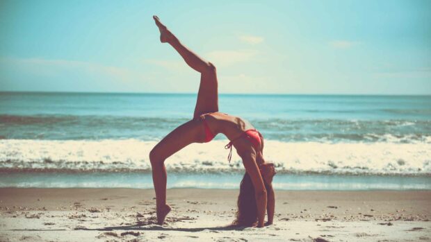 Woman Doung Yoga On A Beach In The Morning
