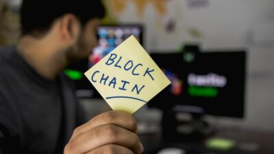 Person Holding Sticky Note That Says &Quot;Blockchain&Quot;