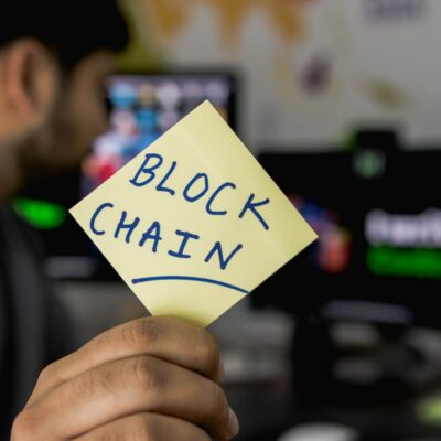 person holding sticky note that says "blockchain"