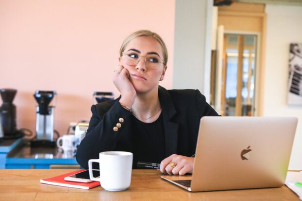 Bored Woman In Black Long Sleeve Shirt Using Macbook Laptop