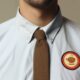 Coffee Badging Job Trend - A man wearing a shirt and tie with a coffee logo on it, displaying his passion for coffee.