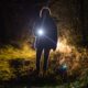 Woman With A Flashlight In The Woods