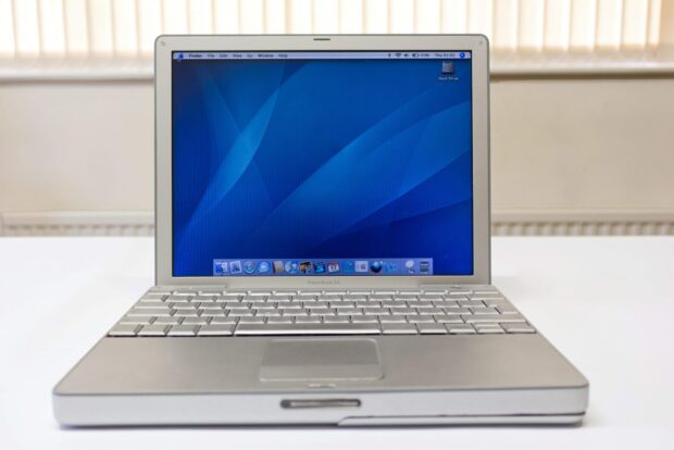 Apple Powerbook Laptop - White Laptop Computer Turned On Displaying Blue Screen