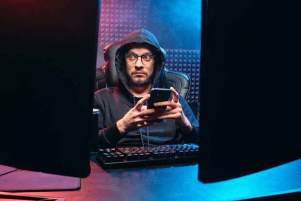 A Hacker Looking At His Computer Screens