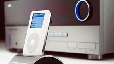 Harmon Kardon Bridge iPod Dock - A Harmon Kardon iPod dock seated atop a stereo.