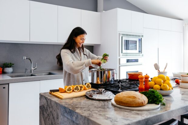 Woman Smiling While Cooking Healthy Foods
