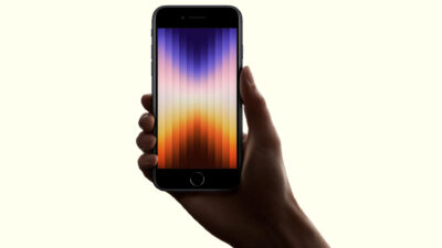 Iphone Se: A Hand Holding A Smartphone With A Colorful Gradient Screen Displaying Vertical Bars, Possibly The Upcoming Iphone Se 4 Aiming To Capture The Mid-Range Smartphone Market.