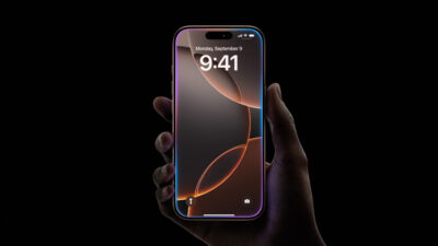 A Hand Holds A Smartphone Displaying 9:41 On The Clock And Monday, September 3 On The Screen. The Phone Has A Colorful Screen And A Black Background.