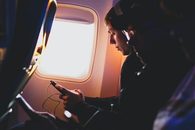 Man Watching A Movie On His Smartphone During His Flight On An Airplane