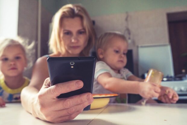 Busy Mom With Kids Using A Smartphone