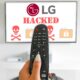 Lg Tv Hacked - A Person Holding A Remote Control Aimed At An Lg Tv Displaying &Amp;Quot;Security Update&Amp;Quot; With Skull And Lock Icons.