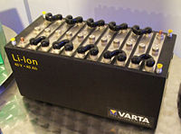 A Black Varta Lithium-Ion Battery Pack With Multiple Cells, Labeled &Quot;Li-Ion&Quot; And &Quot;43V 6.5Ah,&Quot; Is Displayed On A Metallic Surface, Promising Enhanced Battery Life For Devices Like Laptops And Iphones.