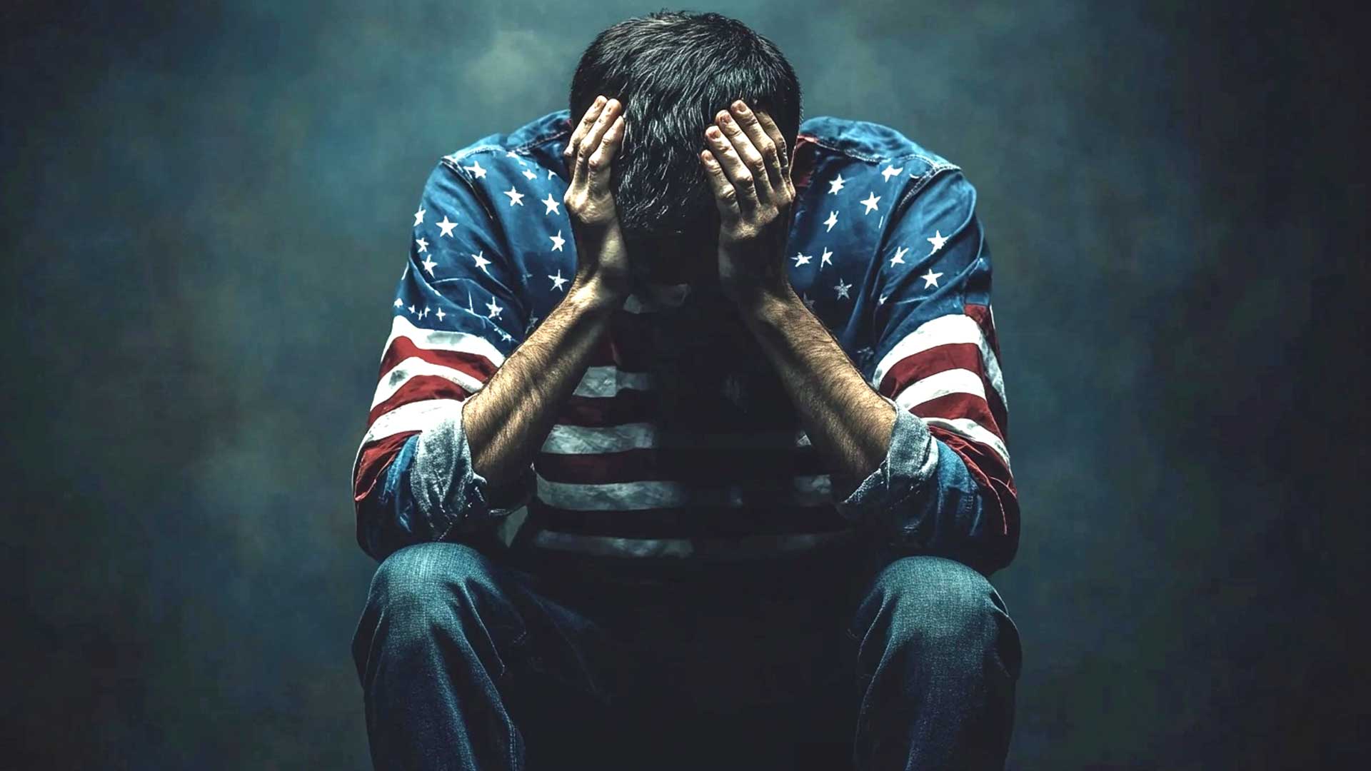 Sad Man Gender Divide - In A Dimly Lit Setting, A Person Wearing An American Flag-Patterned Shirt Sits With Their Head In Hands, Contemplating The Impact Of Trump'S Re-Election.