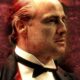 Marlon Brando from The Godfather - An older man, reminiscent of a character from The Godfather, wearing a black bow tie and suit, looks to the left against a dark, textured red background. His gaze suggests an air of spontaneity as if he's about to deliver lines without cue cards.