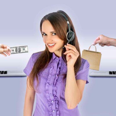 A Woman Wearing A Headset Stands Between Two Laptops, One Extending Money And The Other Offering A Shopping Bag, Embodying The Seamless Transactions Of An Online Store.