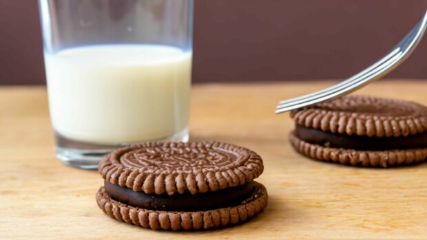 Two Oreo Cookies, A Fork And A Glass Of Milk.