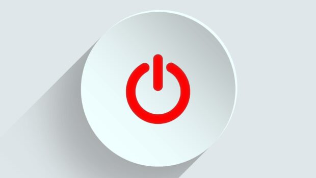 A Red Power Button With A Shadow On A White Background.