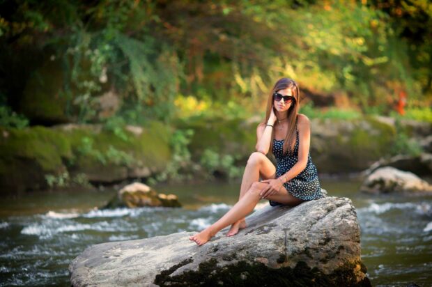 Cute Girl Sitting By A River