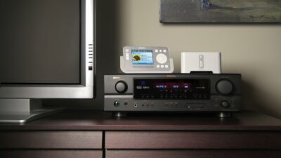 Sonos ZonePlayer ZP80 - A home entertainment setup featuring a television, an audio-video receiver, a wireless controller, and a speaker on a wooden sideboard promises to deliver the Home Audio Revolution.