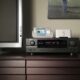 Sonos ZonePlayer ZP80 - A home entertainment setup featuring a television, an audio-video receiver, a wireless controller, and a speaker on a wooden sideboard promises to deliver the Home Audio Revolution.