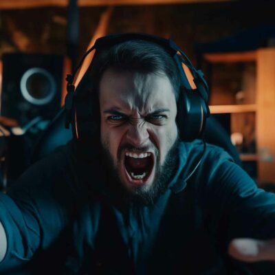 Man Wearing Headphones Screams And Extends His Arms Towards The Camera In A Dimly Lit Room, Desperately Trying To Stop Apple Music From Automatically Playing.