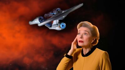 A Woman In A Yellow Shirt Is Looking Up At A Uss Enterprise Star Trek Ship.