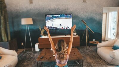 woman sitting on brown sofa watching TV